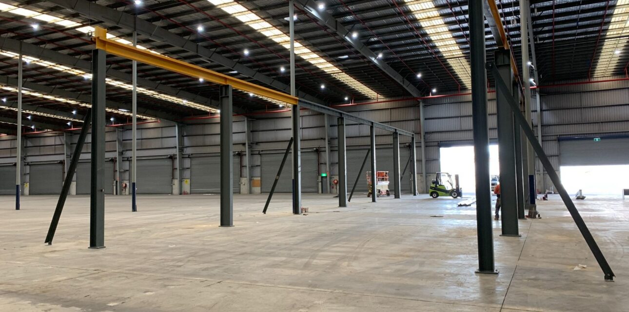 Crane runway and supporting steel installation inside a large industrial warehouse