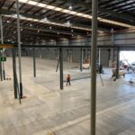 Industrial crane runway system being installed inside a large warehouse facility