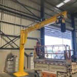 Free‑standing jib crane with Yale electric hoist being installed.