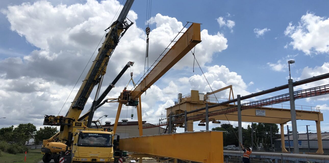 Mobile crane lifting portal crane beam during installation