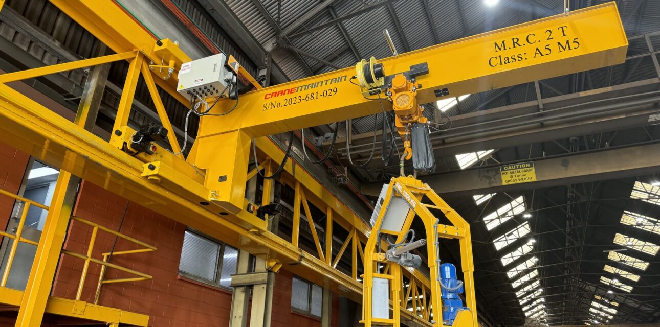 Overhead crane with custom lifting attachment and control cabin.