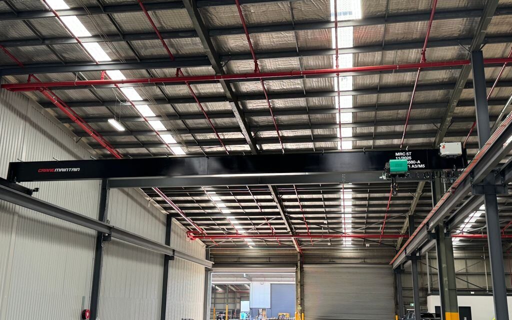 Single girder overhead crane installed in industrial warehouse.