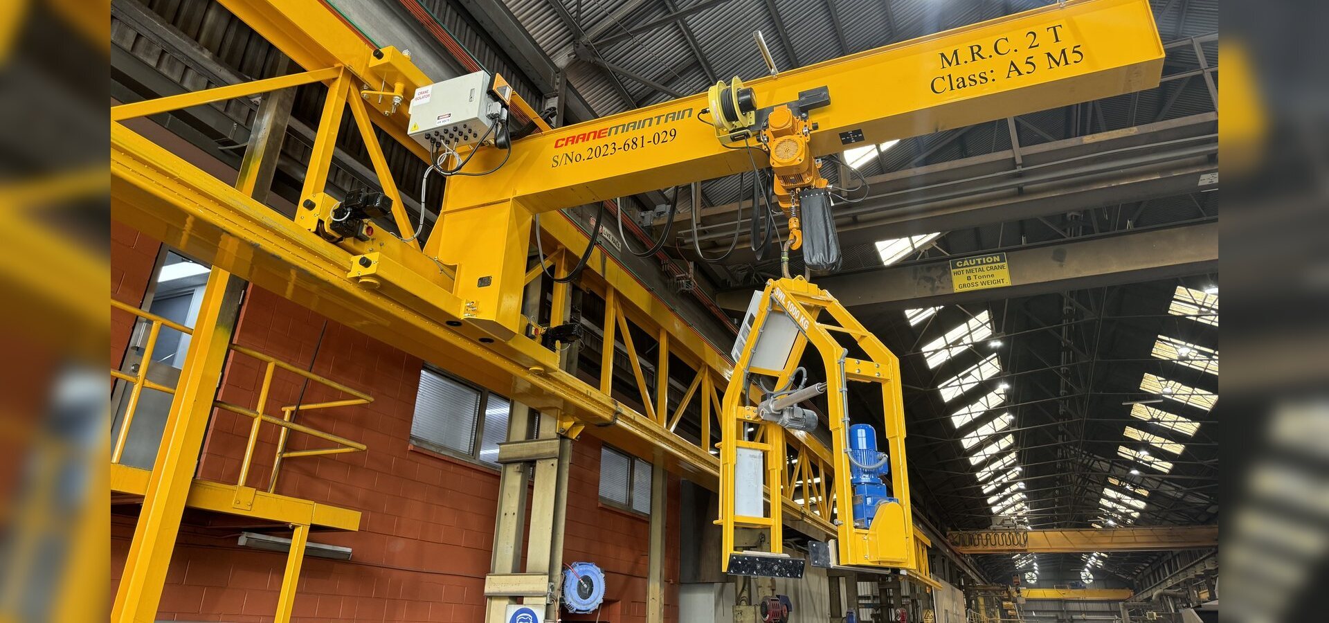 Custom overhead crane with specialised lifting attachment inside an industrial workshop